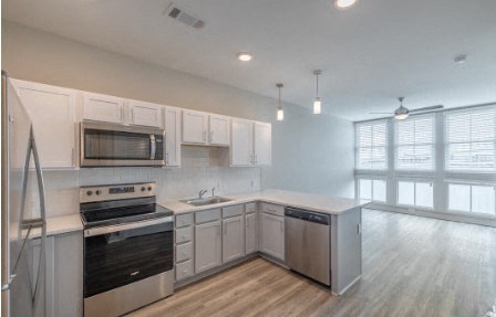 A kitchen with white cabinets and stainless steel appliances.